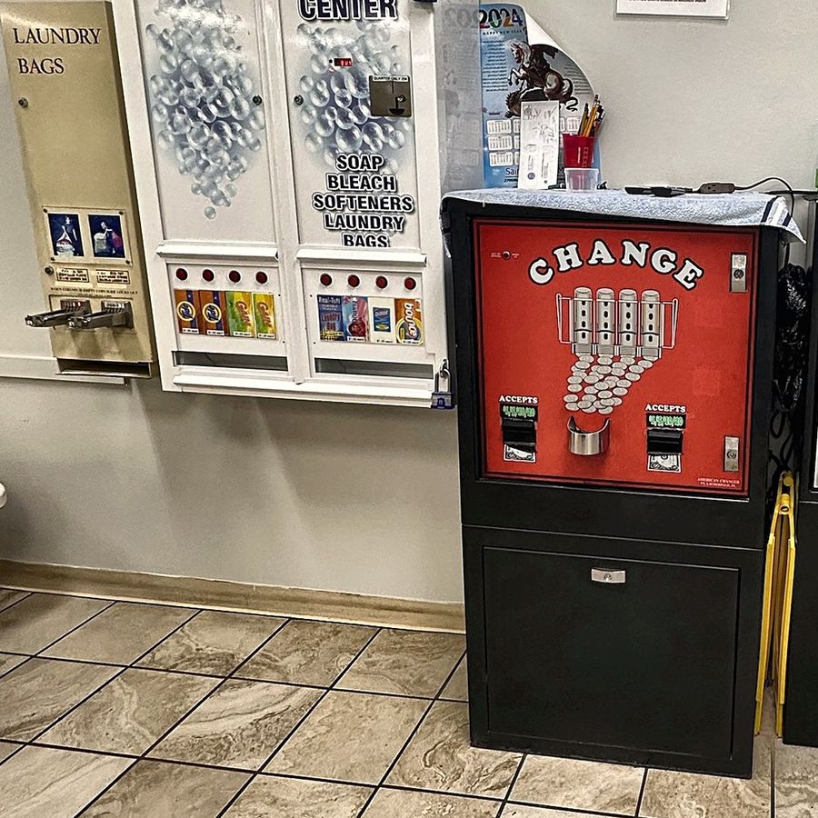 Soap vending cabinet and coin change machine by the wall at Coin Laundry