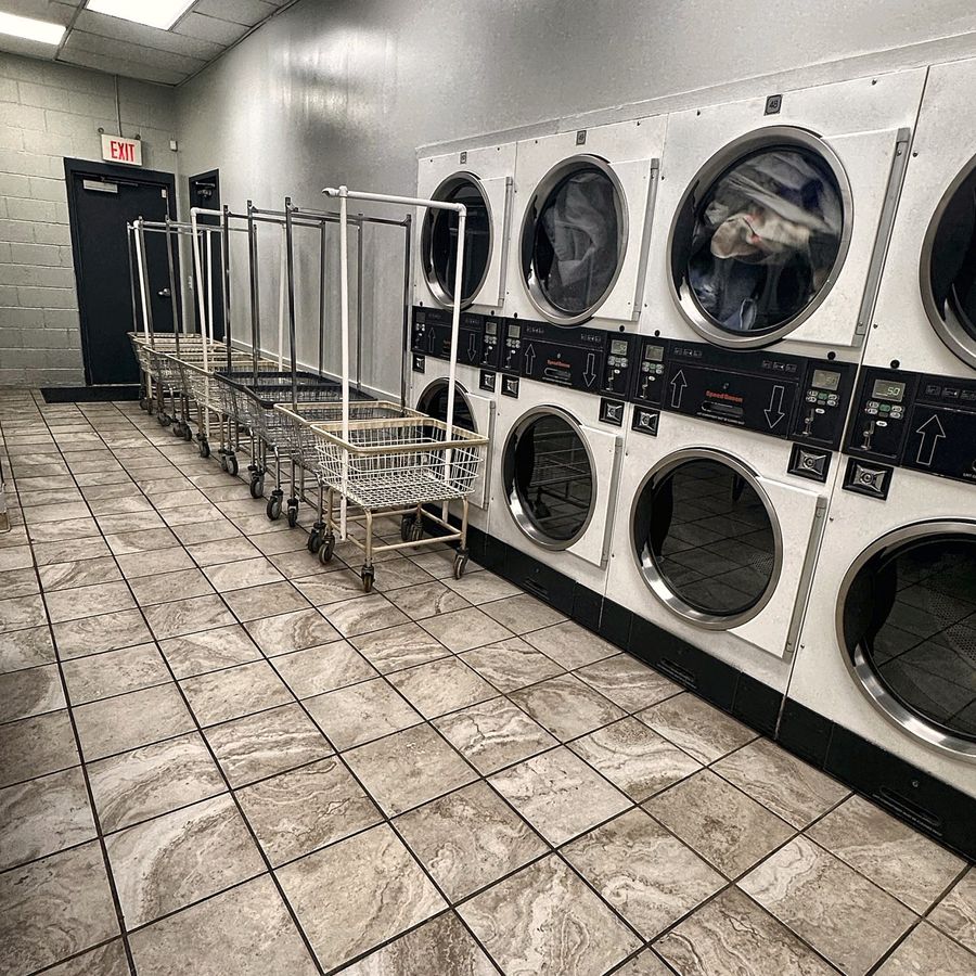 Large-capacity stacked dryers with laundry carts ready beside them